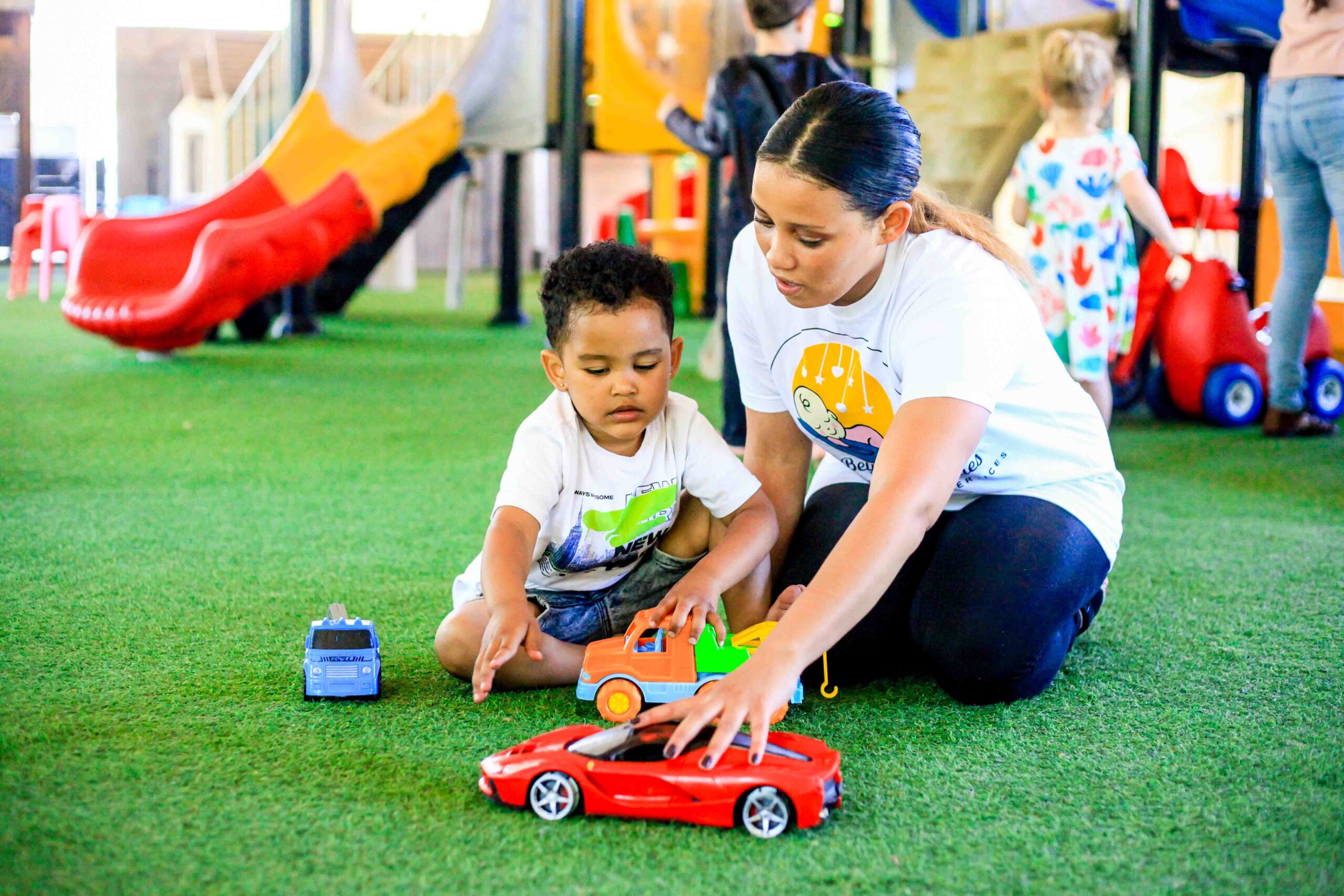 Above & Beyond Nanny playing toy car with toddler
